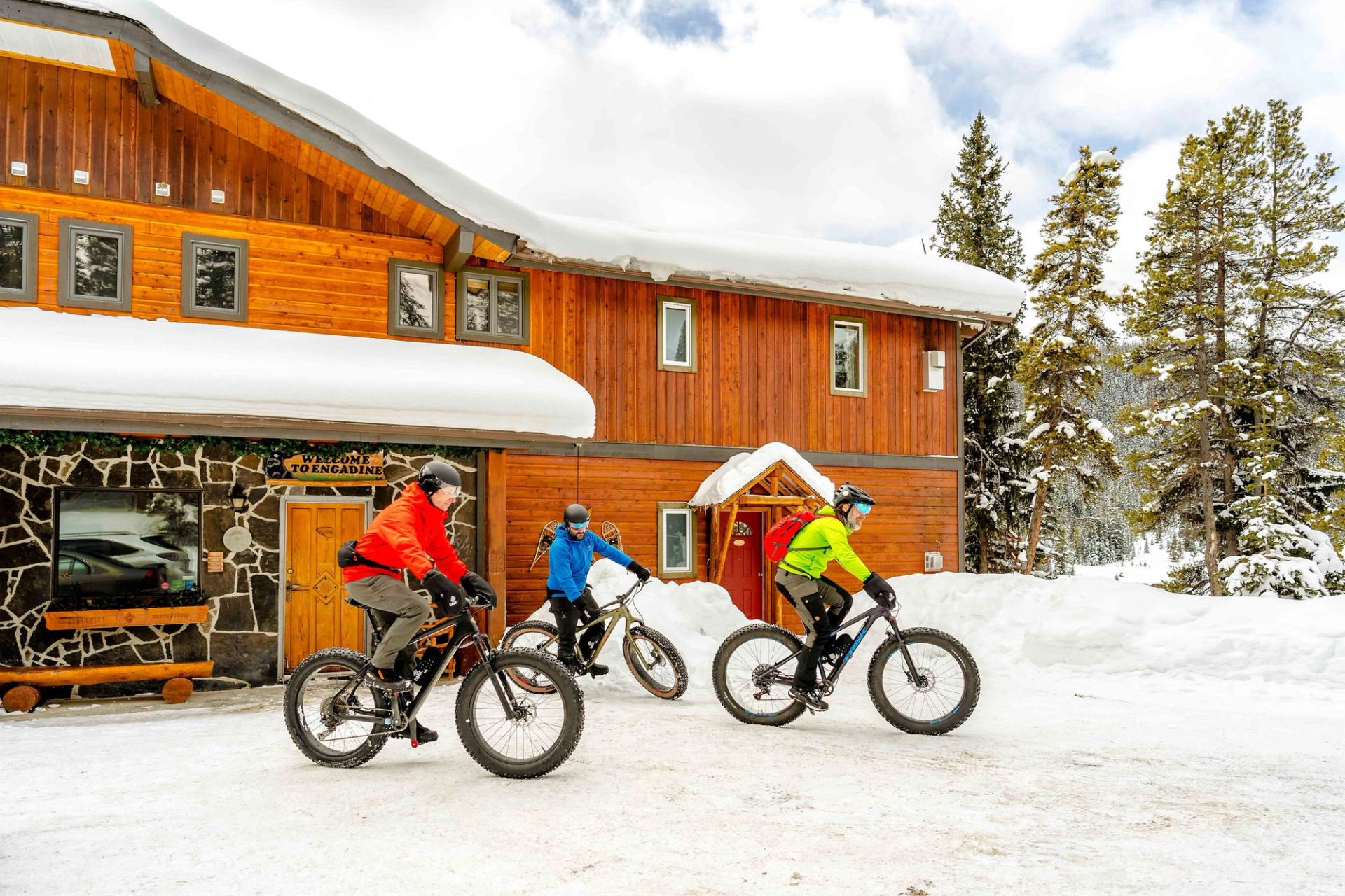 Group of fatbikers gathers in front of Mount Engadine Lodge, ready to start fatbiking in Kananaskis Country.