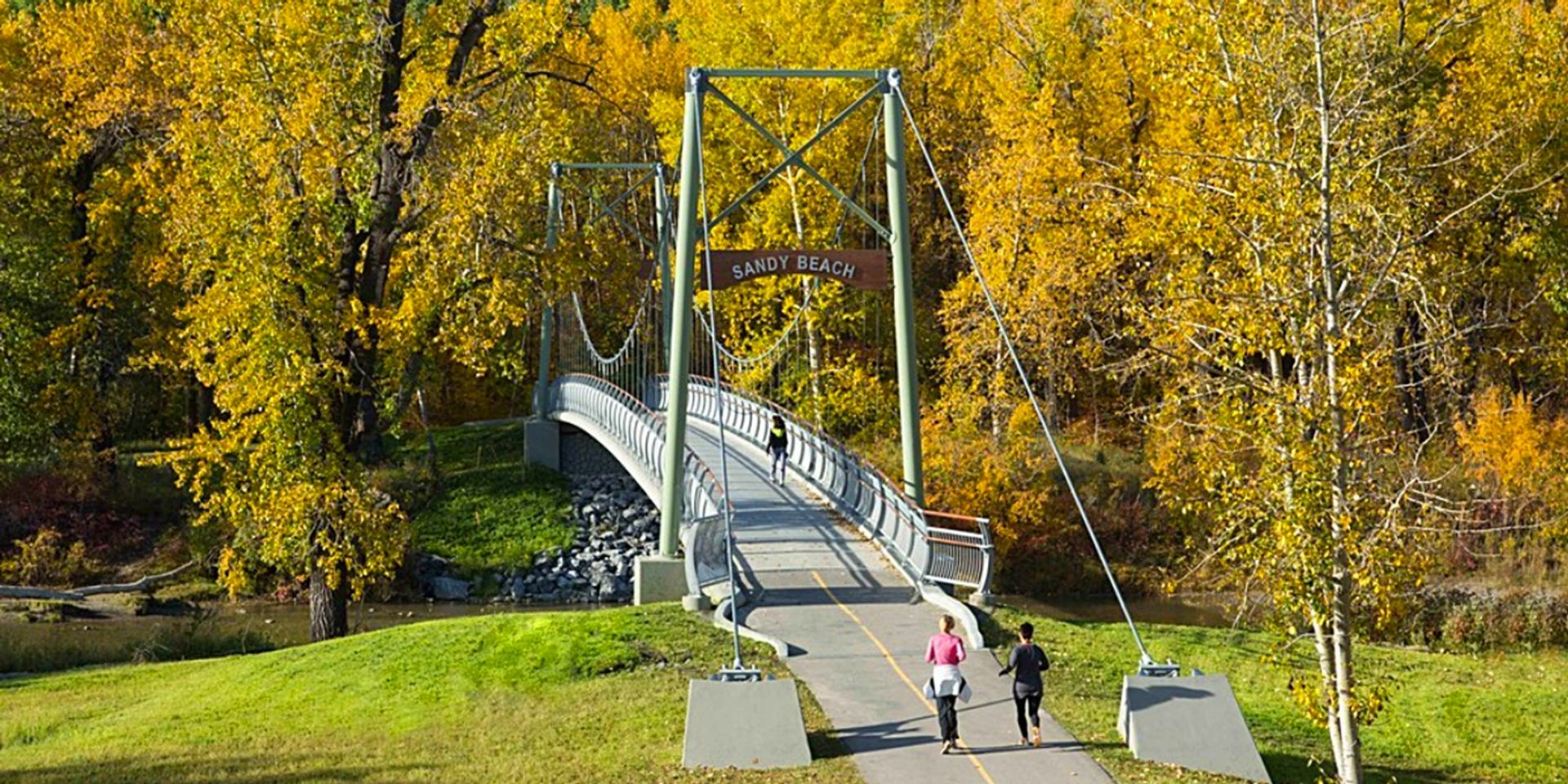 Bridge with fall foliage trees around entrance to Sandy Beach