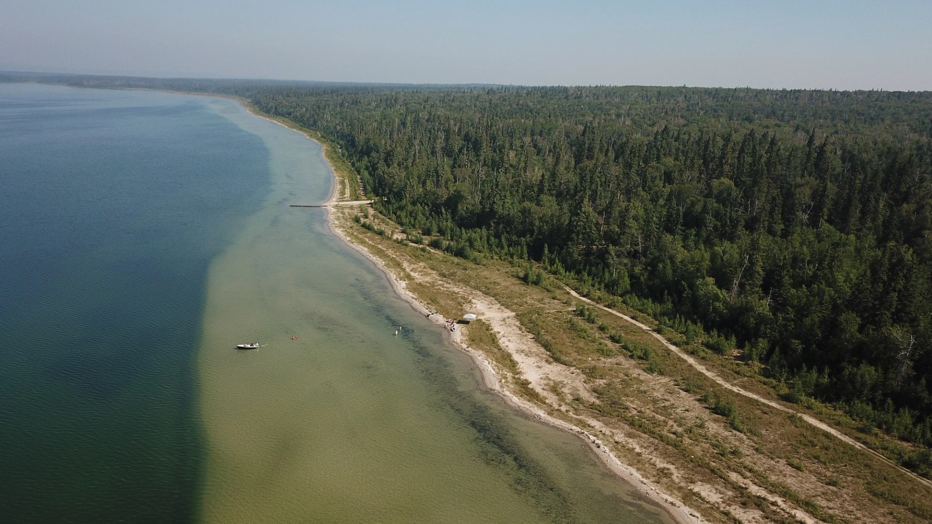 Aerial view of lake, forested shore, dock, and boats near Seibert Lake.
