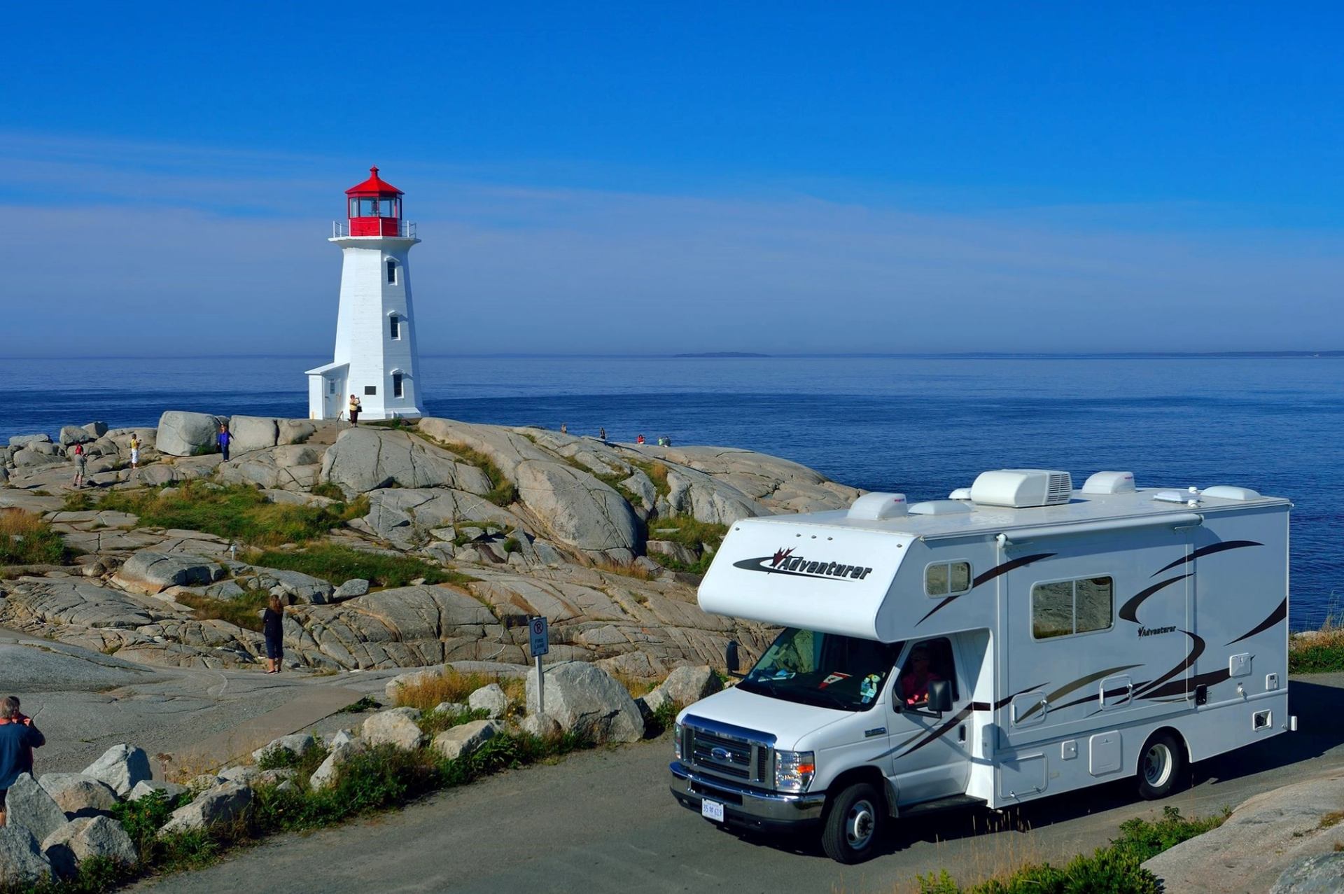 An RV parked by a lighthouse
