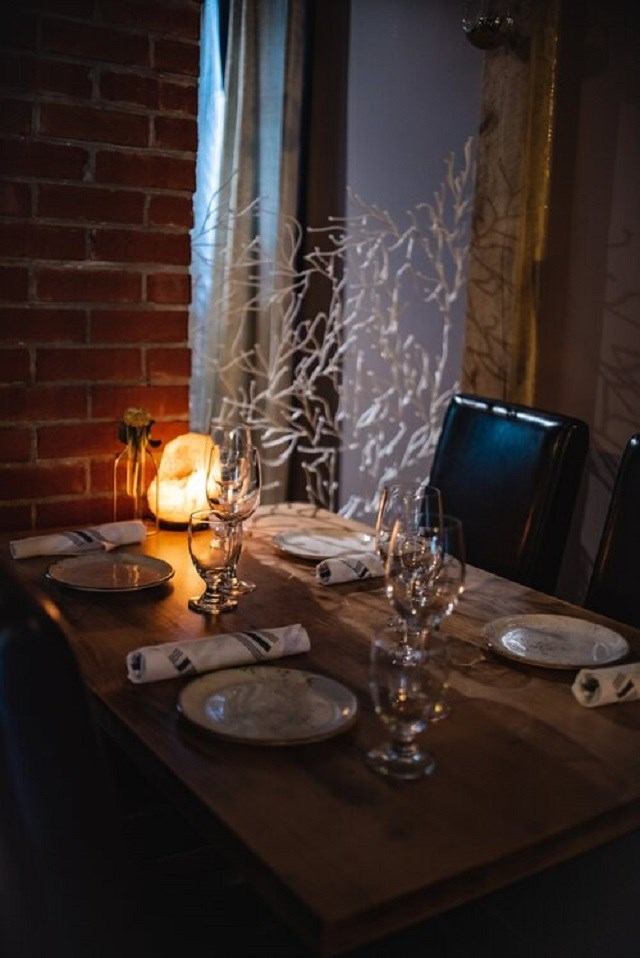 A dining table with plates, glasses, and a candle, creating a warm ambiance.