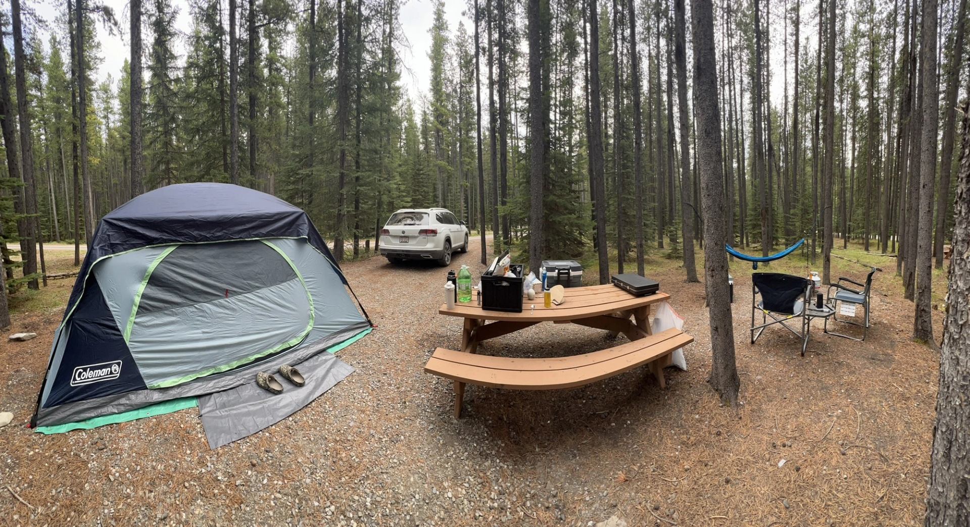 Campsite Setup with a bench and tent and chairs.