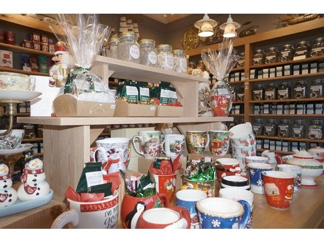Festive tea shop interior with holiday mugs, gift sets, and jars of loose-leaf tea.
