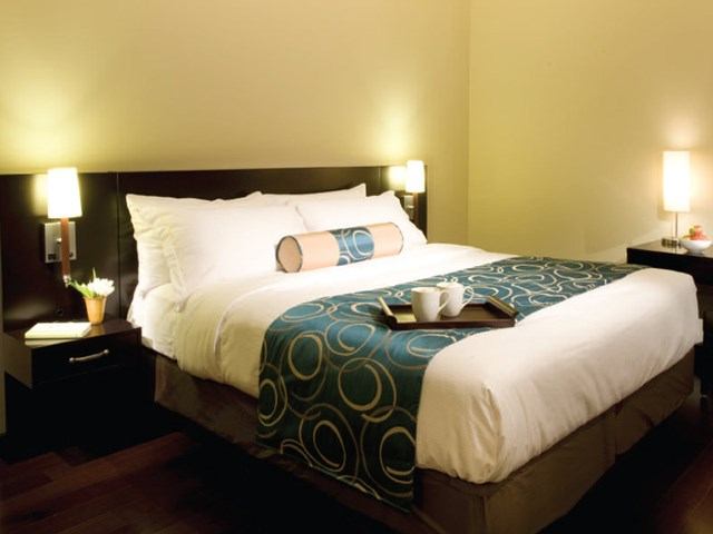 Cozy hotel room with a king bed, modern decor, and soft lighting.