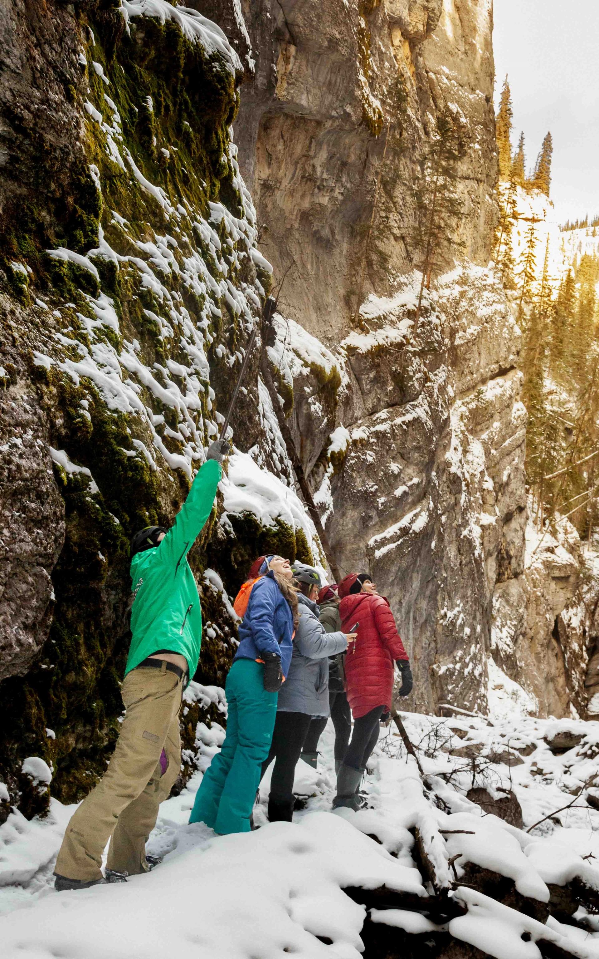 Group walking through snow-covered canyon with steep rock walls