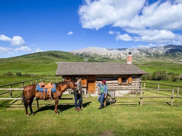 Guests standing in front of a structure before horseback riding at Centre Peak High Country Adventure.