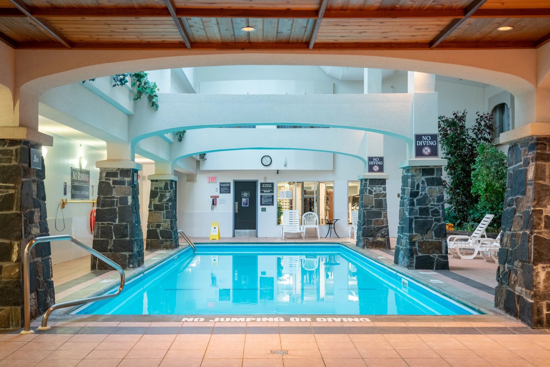 Indoor pool with stone pillars and seating area at The Rundlestone Lodge.