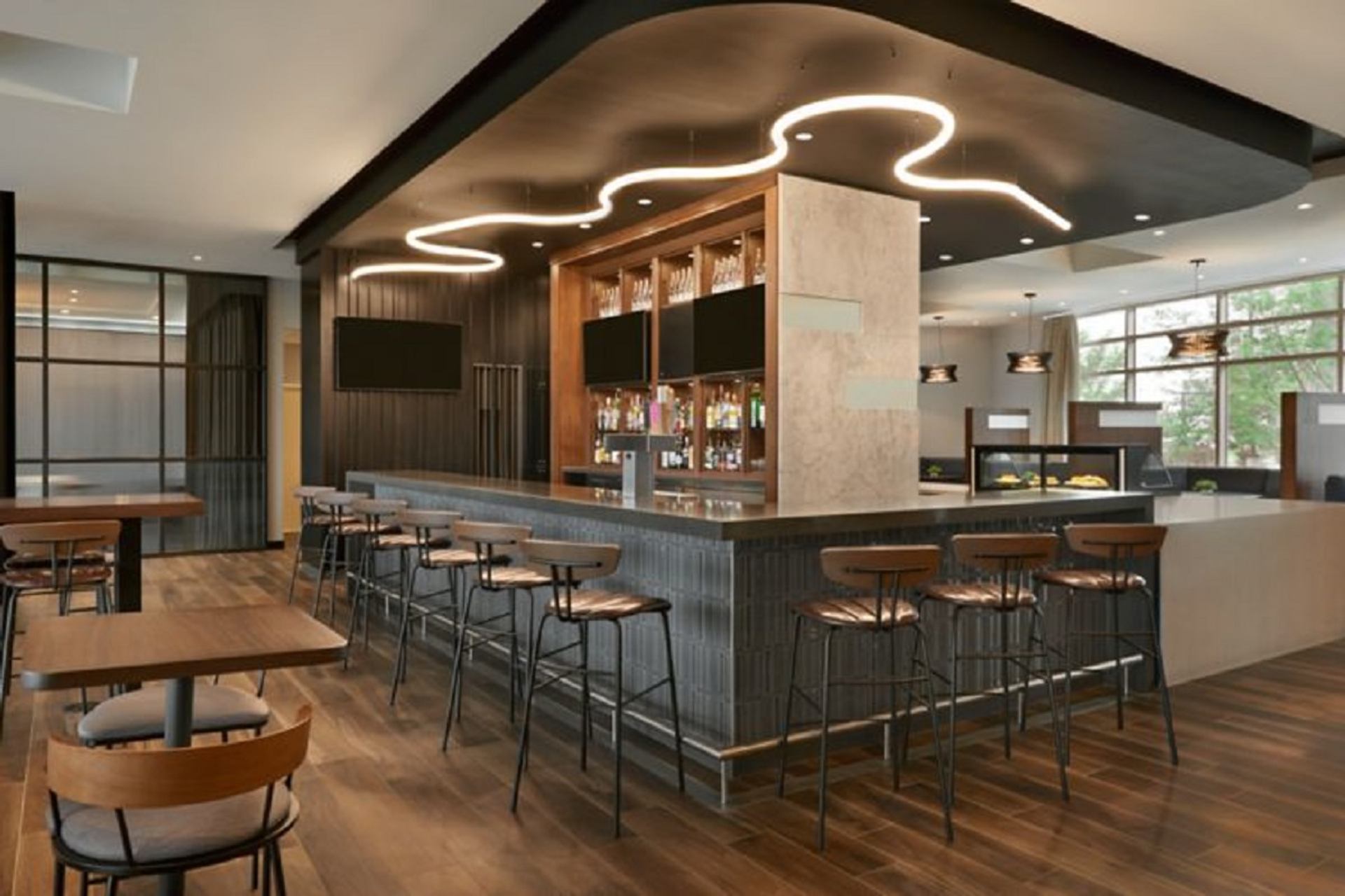 Contemporary hotel bar with high-top seating and modern lighting at Courtyard by Marriott Calgary Airport.