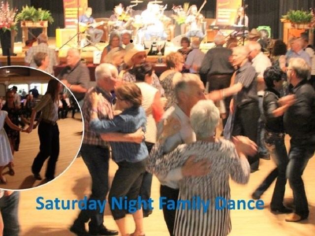 Crowd dancing in a hall with live band on stage and event title text.