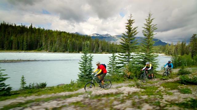 People mountain biking along the Bow River in Jasper.