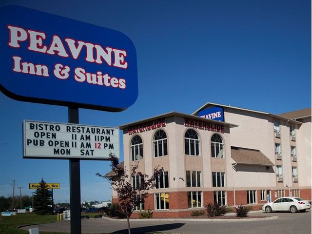 Hotel exterior with signage for Peavine Inn & Suites and on-site bistro and pub.