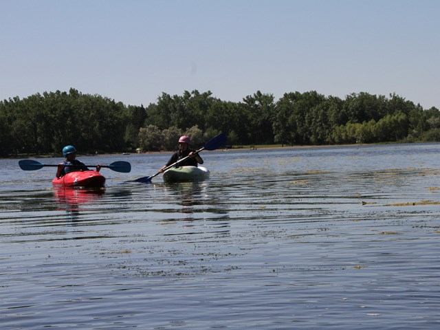 Two people kayaking on the lake.