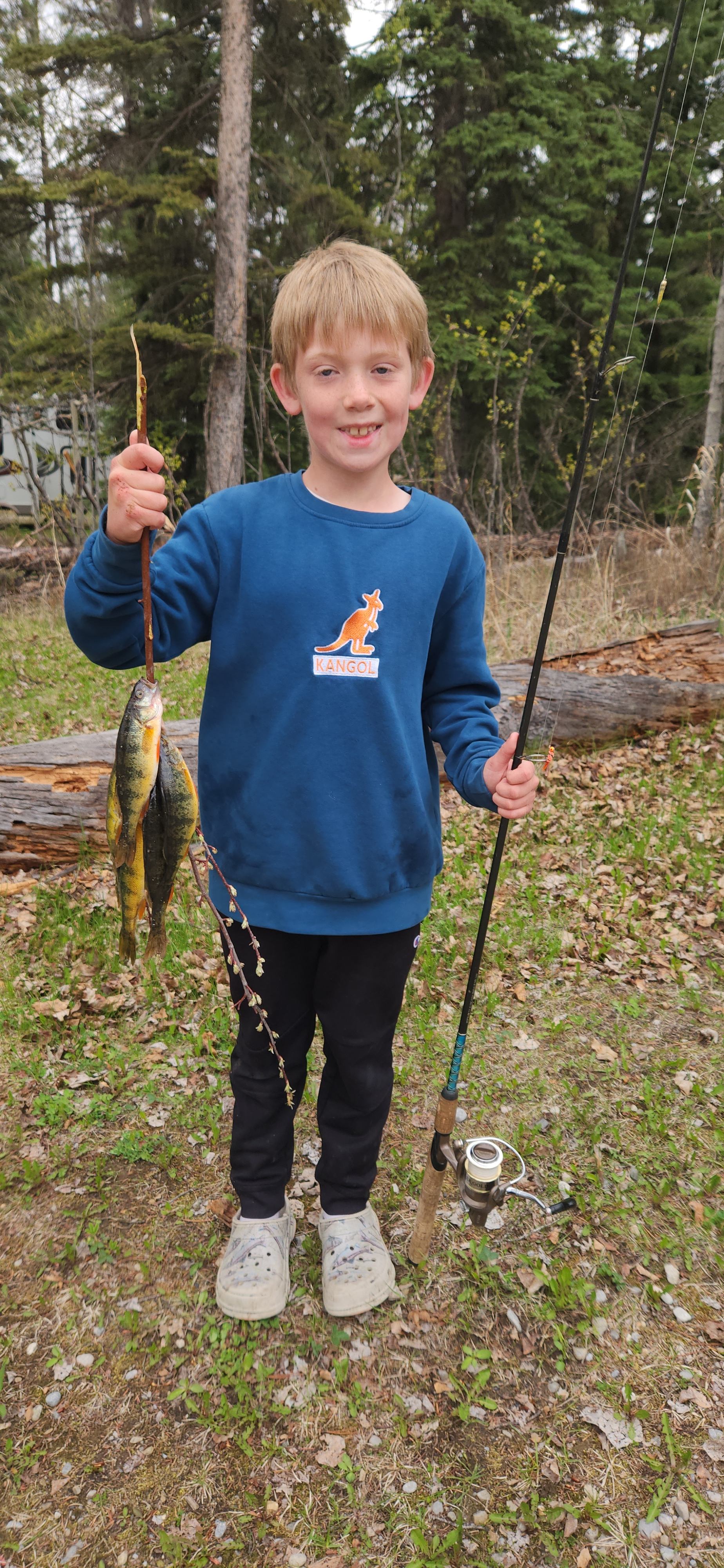 Child with fishing rod and catch at Burnstick Lake Campground.