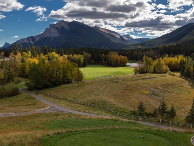 Golf course with golden fall trees and distant mountain view