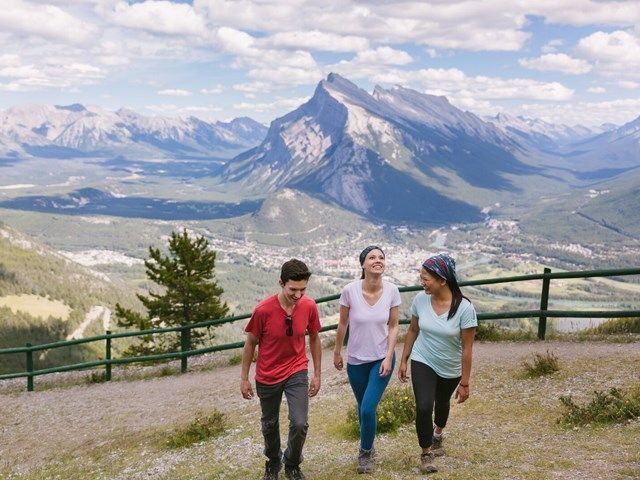 People walking around at taking in the sights at the top of Mt Norquay.