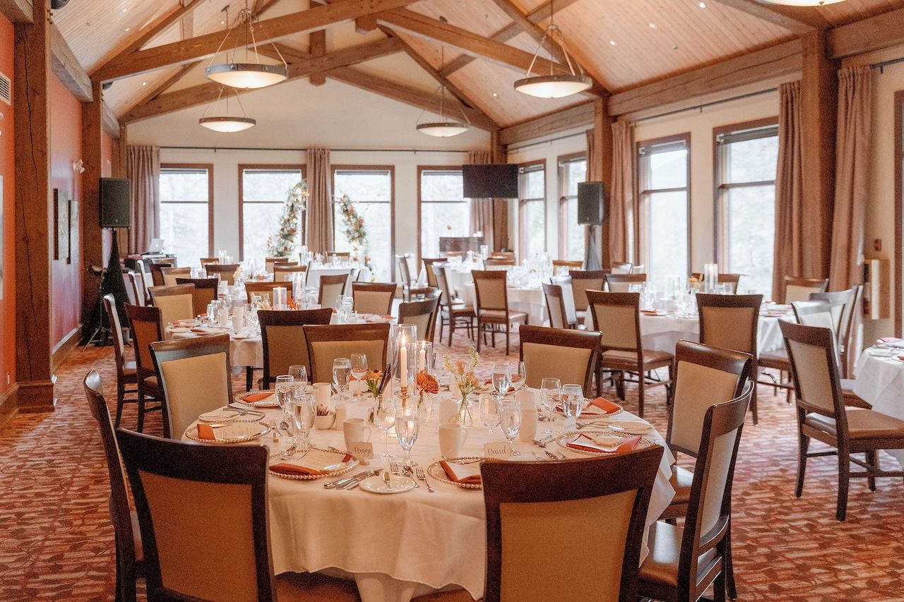 Reception hall with round tables, décor, and large windows