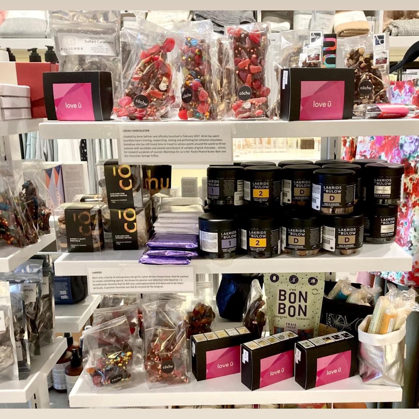 Shelf display with Bon Bon boxes, candy bags, and jars of chocolate treats.