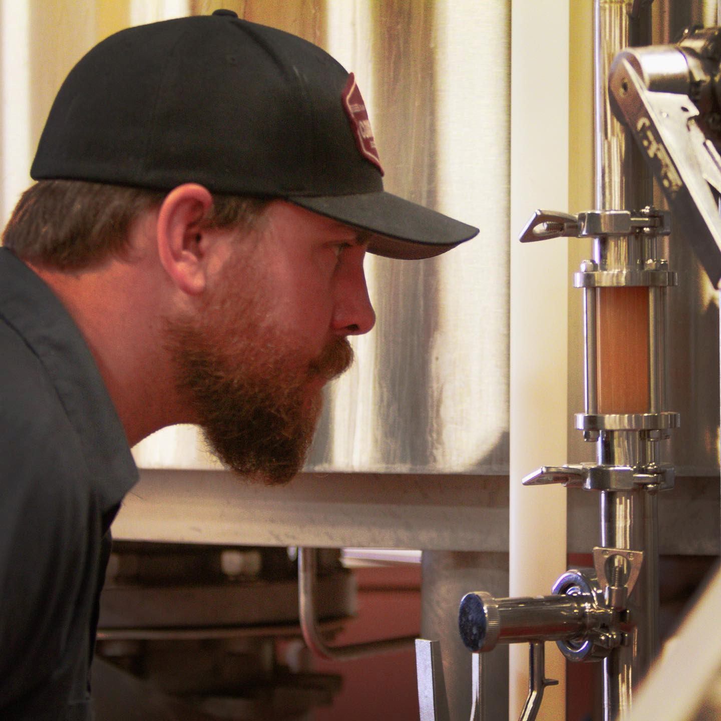 Brewer inspecting a tank at Common Crown Brewing Co.