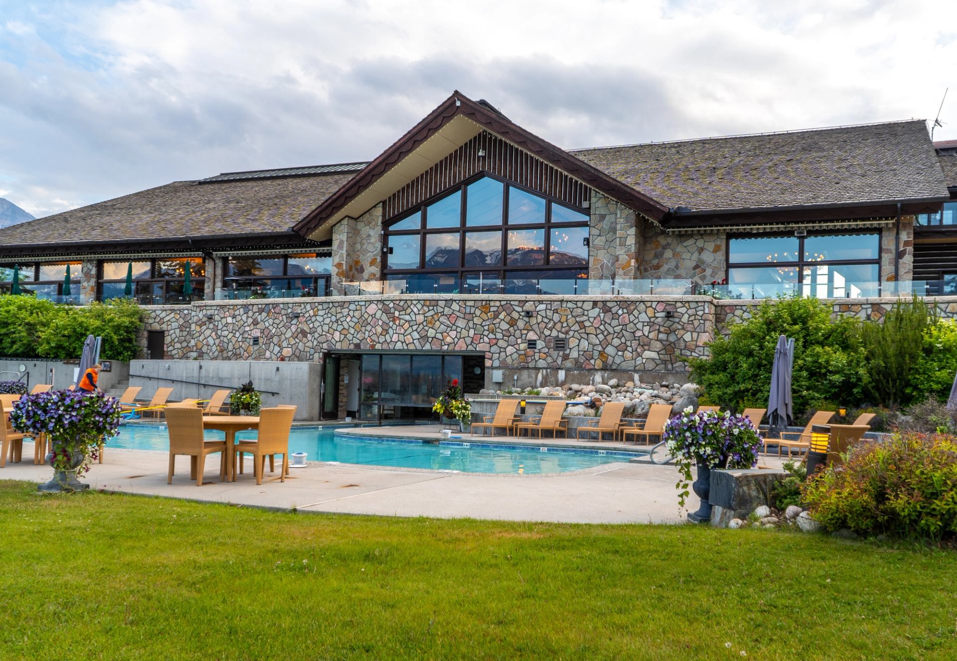 Poolside at Fairmont Jasper Spa with chairs, umbrellas, and greenery in a tranquil setting.