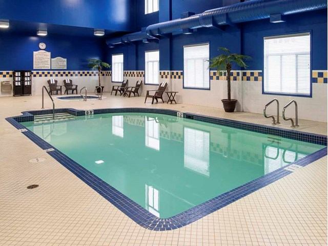 Indoor Hilton Garden Inn pool with bright blue walls and seating area.