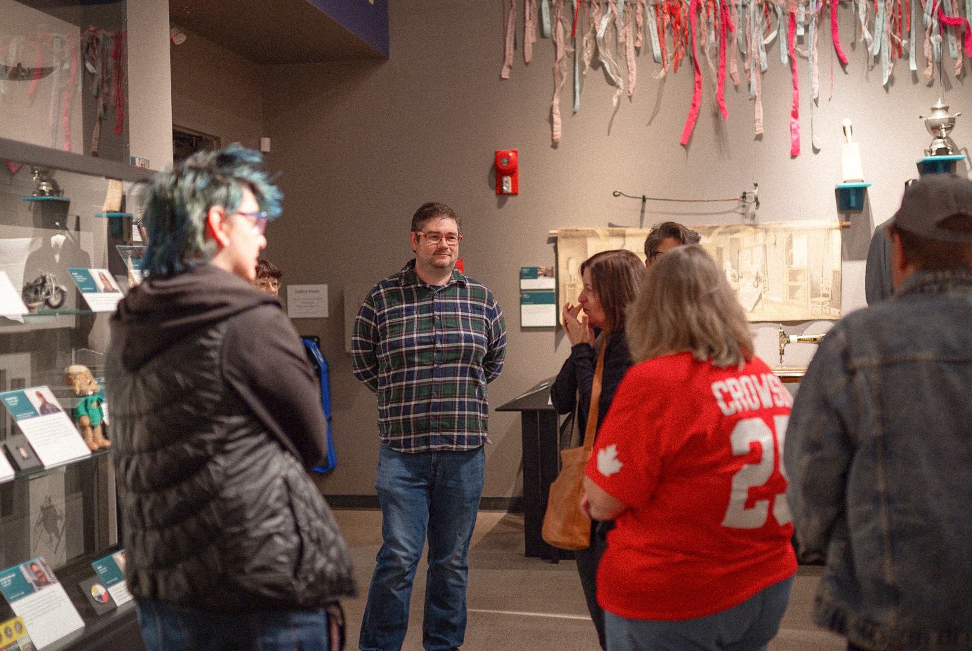 Visitors gathered inside Galt Museum exhibit space with displays and hanging art