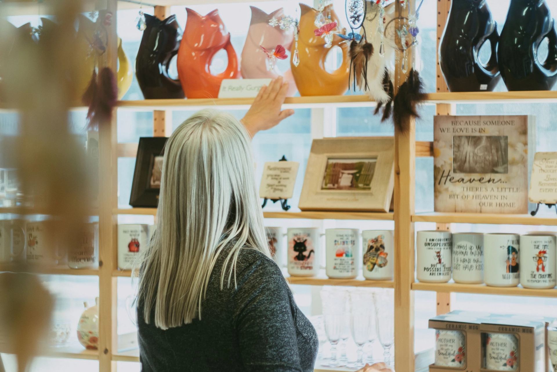 A woman looking at the gift display shelves.