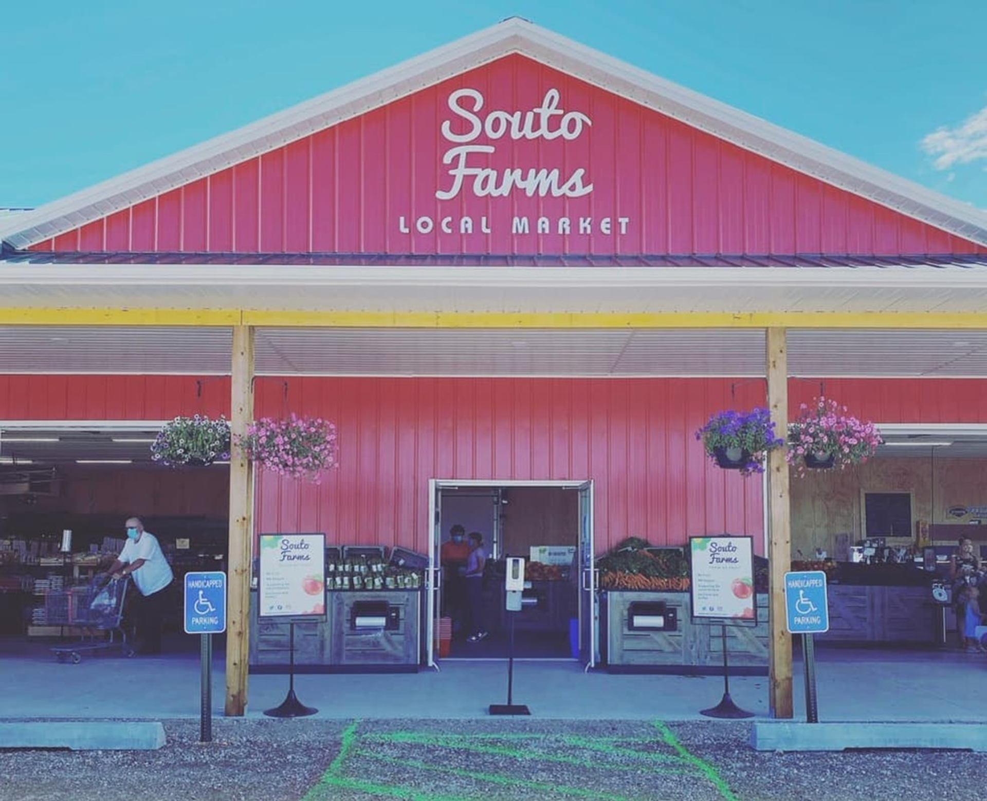 Red Souto Farms local market exterior with hanging flowers and accessible parking signs.
