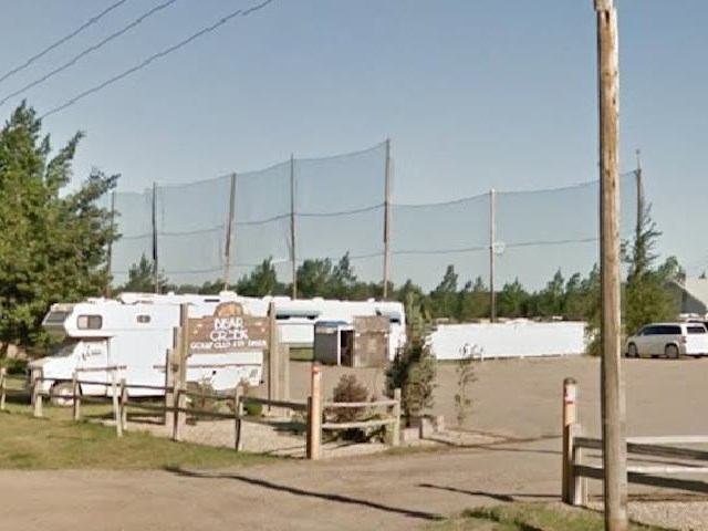 RV parked near fence at Silver Birch Golf Center with tall netted barriers.