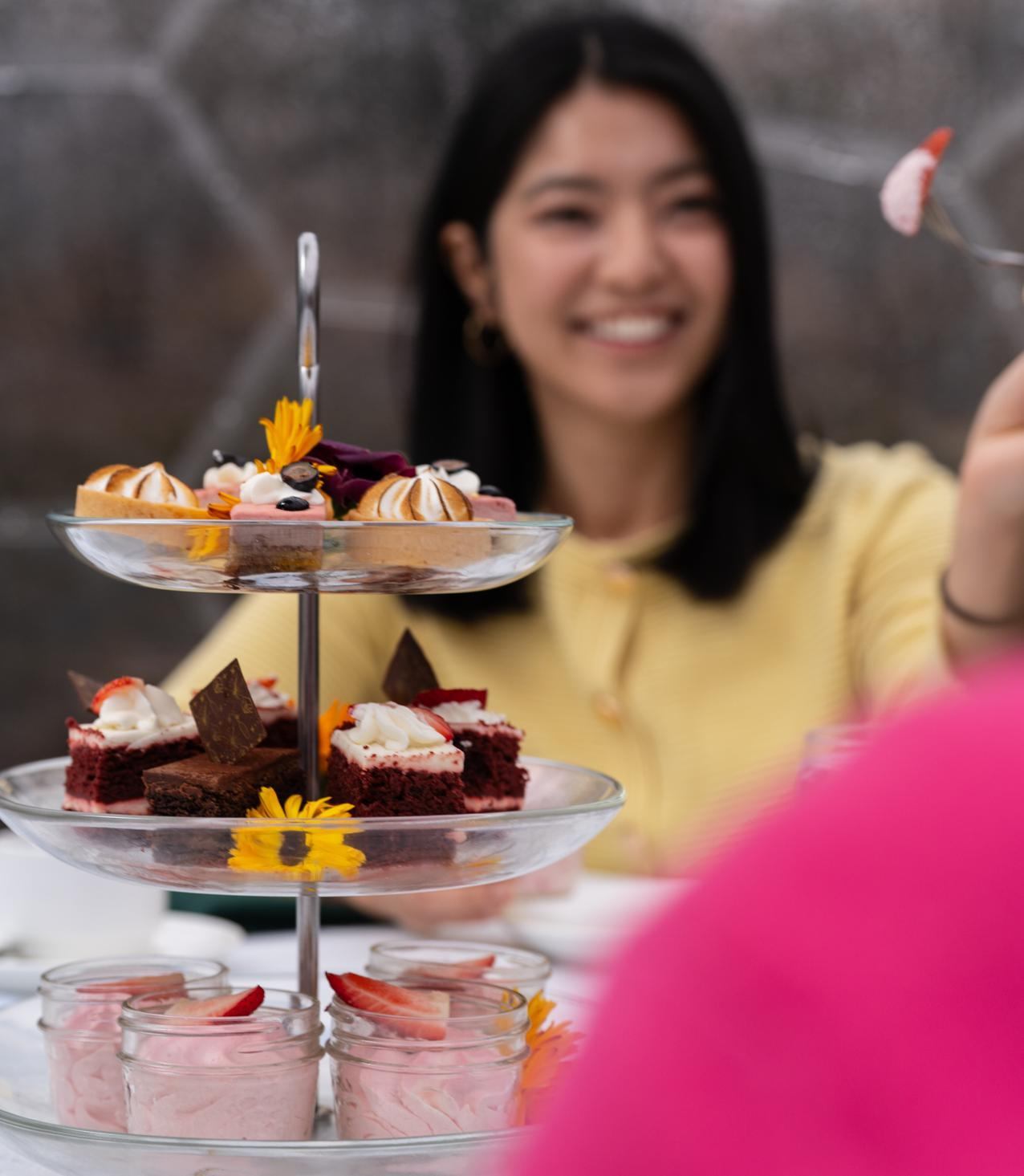 A hand dips bread into a baked cheese dish surrounded by brunch sides.