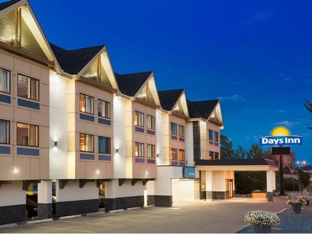 Days Inn hotel exterior at night with lit sign and covered entrance.