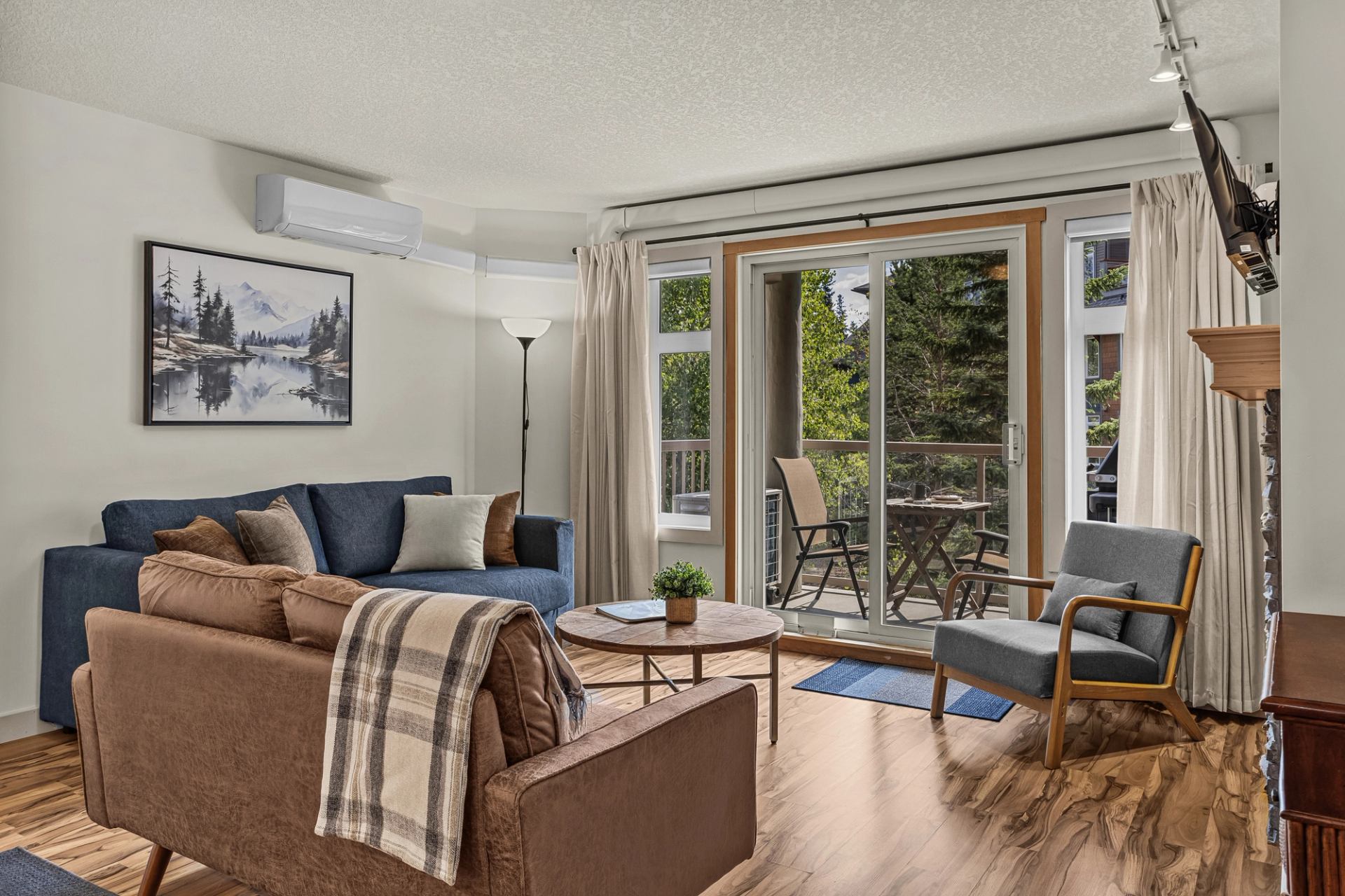 Living room with sofas, armchair, coffee table and sliding doors to a balcony.