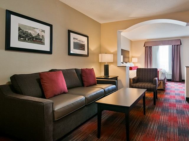 Hotel suite with sofa, coffee table, and bed at Best Western Plus Red Deer.