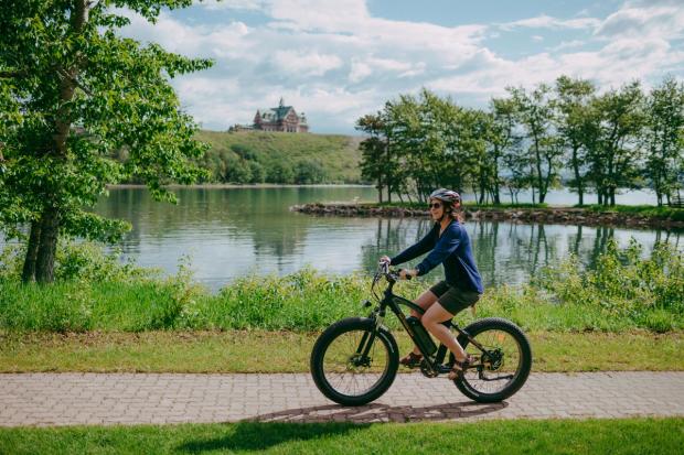 Person riding ebike in Waterton with the Prince Of Wales Hotel in the background.