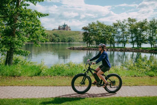 Person riding ebike in Waterton with the Prince Of Wales Hotel in the background.