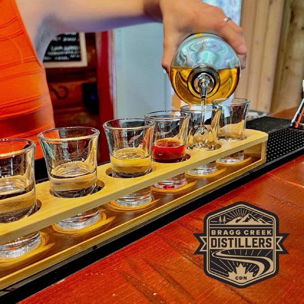 A person pouring a flight of different spirits