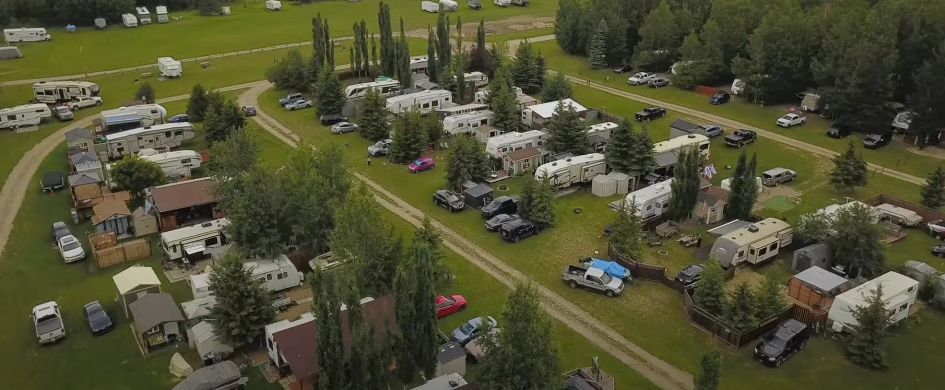 Aerial view of a campground filled with RVs, trailers, and trees near the Pigeon Lake event site.