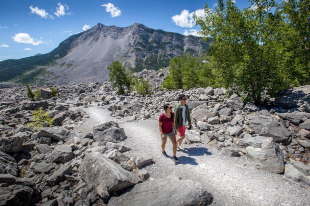 Two people walking on an trail at Frank Slide in the Crowsnest Pass.