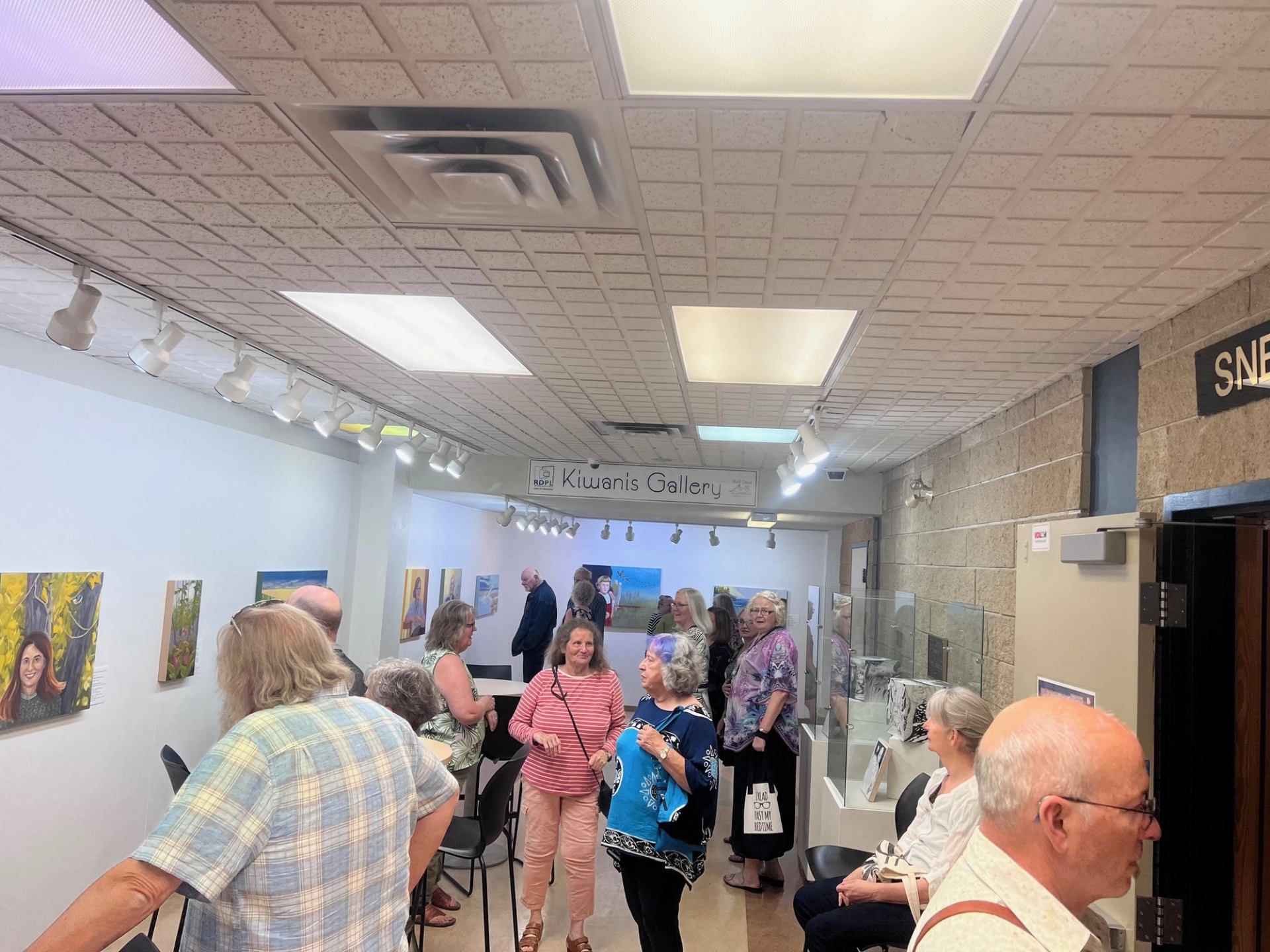 People in the Kiwanis Gallery, admiring the portrait paintings and sculptures.