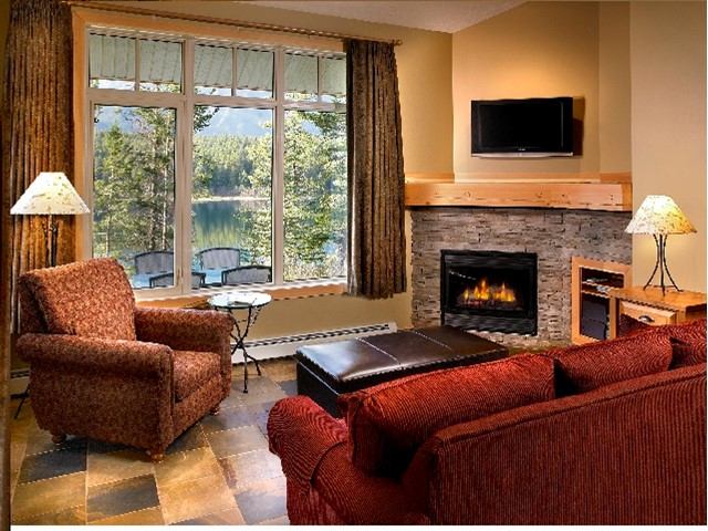 Cozy lakeview lounge with red seating, fireplace, and scenic window.