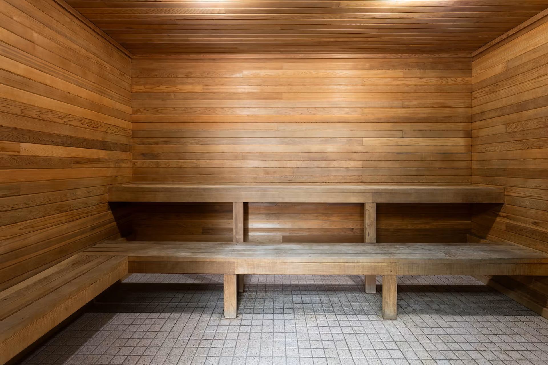 Wooden sauna interior with benches and tiled floor at Travelodge Grande Prairie.