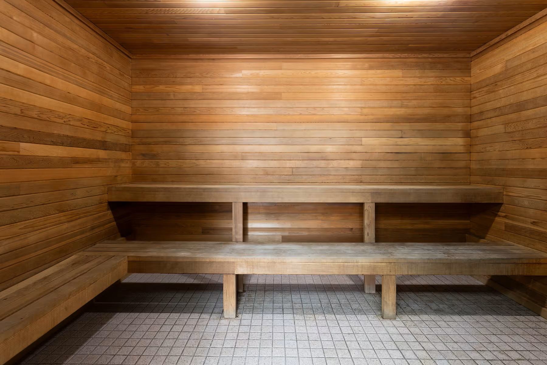 Wooden sauna interior with benches and tiled floor at Travelodge Grande Prairie.