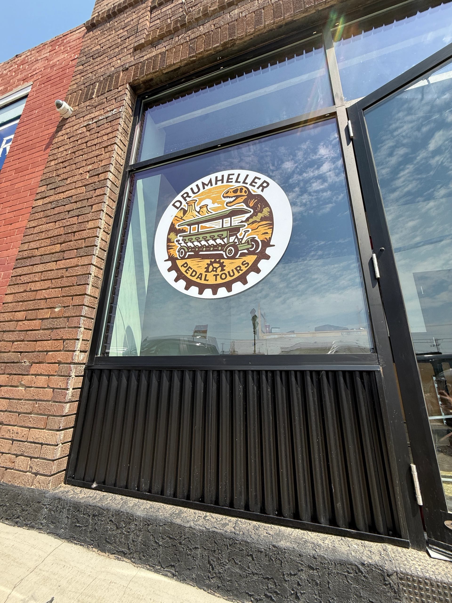 Exterior of Drumheller Pedal Tours with the logo on the entrance door.