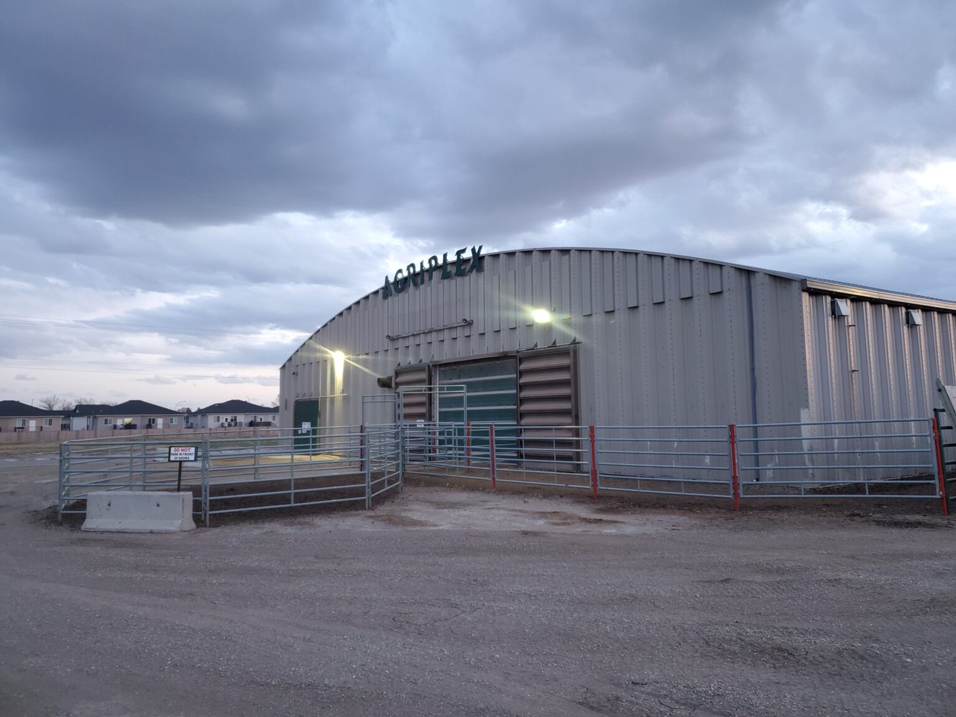 Claresholm Agriplex arena building is surrounded by fencing, gates, and open prairie community grounds.