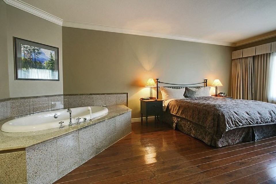 Park Place Inn room with large bed, lamps, and in-room jacuzzi.