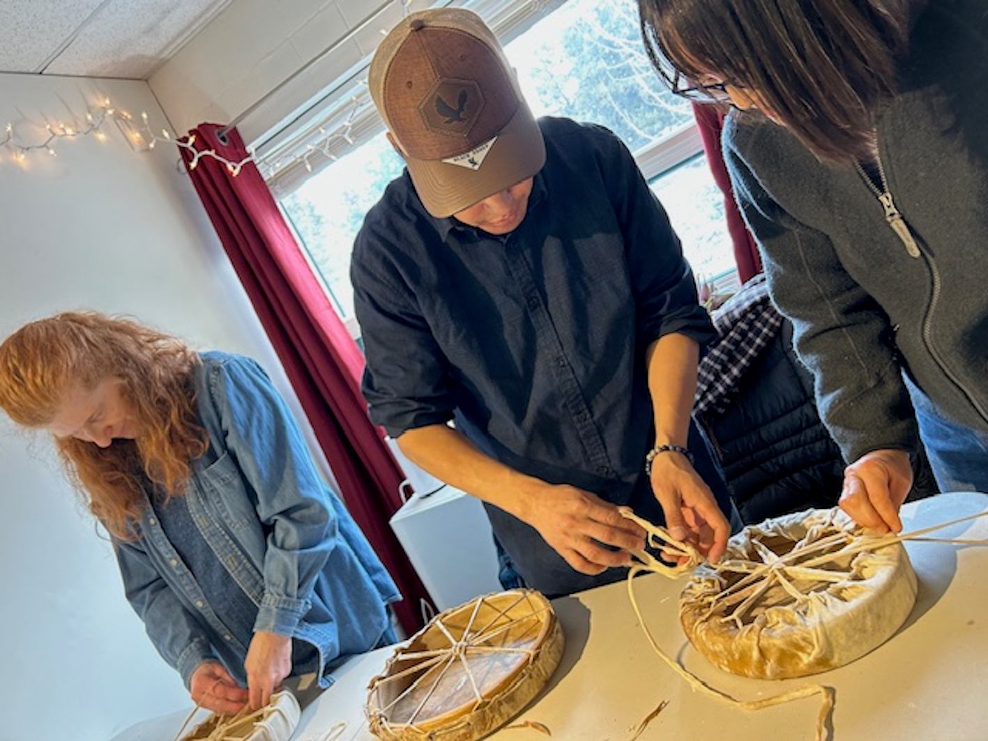 Stoney Artist Kyle Kaquitts showing participants how to make Drums
