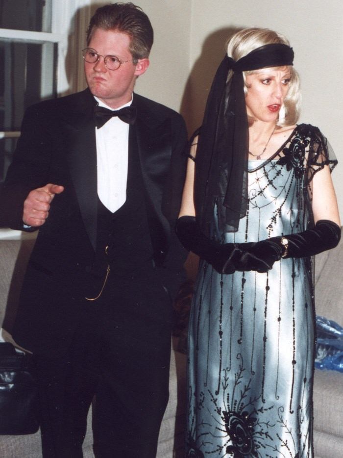 Two people in formal evening wear, including a tuxedo and a beaded gown with gloves.