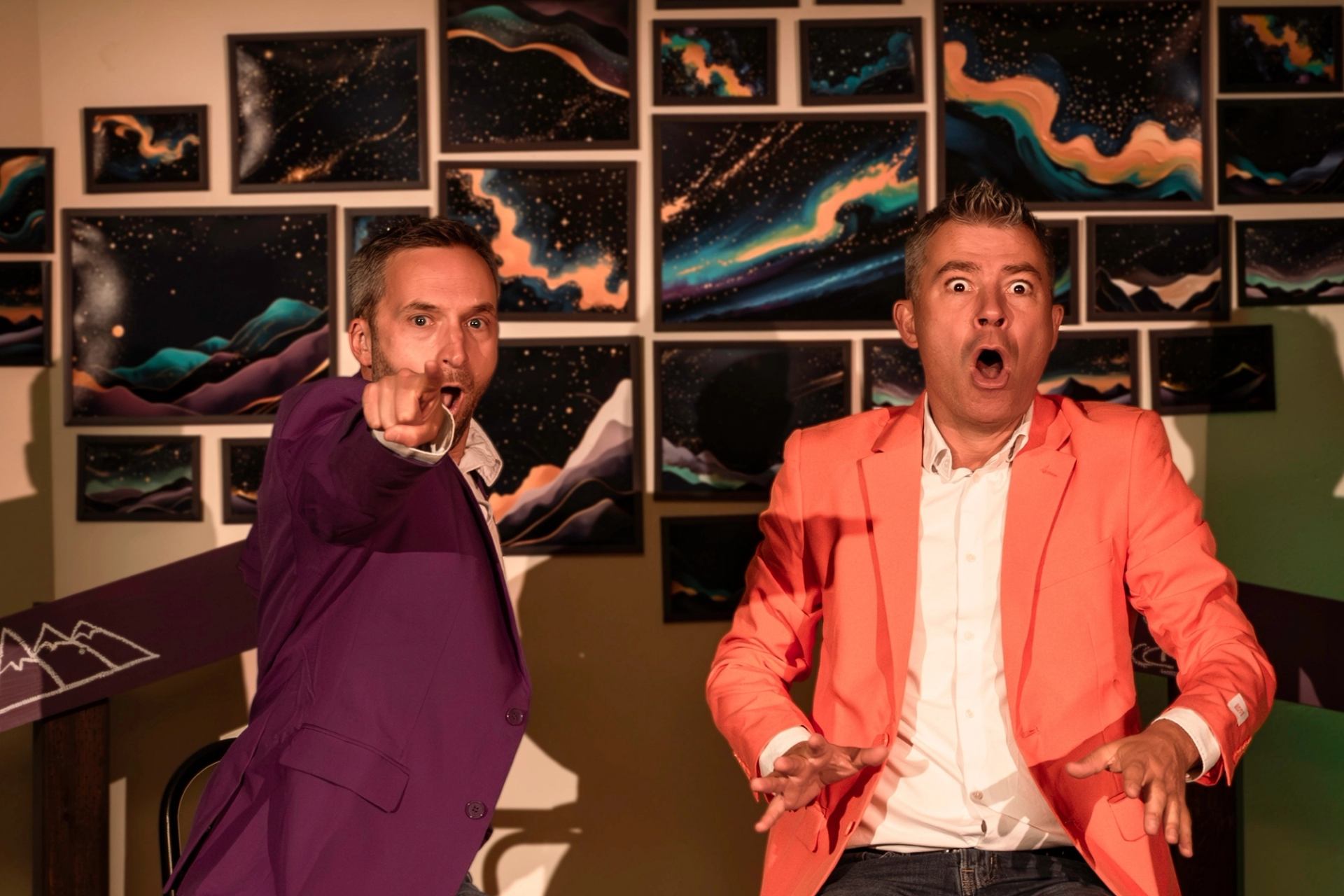 Two performers acting out a lively scene against a colorful backdrop