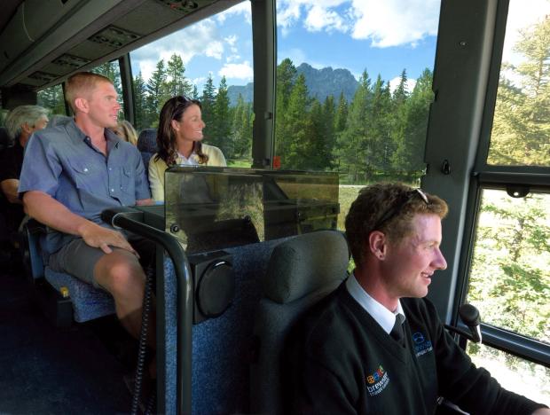 Group of people on a tour bus driving through Banff National Park.