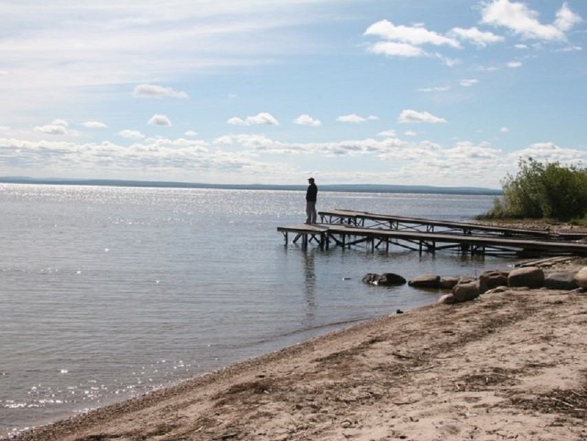 A man stands on piers jutting out into Lesser Slave Lake.
