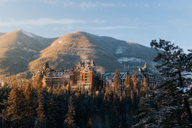 Landscape shot of the Fairmont Banff Springs in Banff; surrounded by trees and Sulphur Mountain behind.